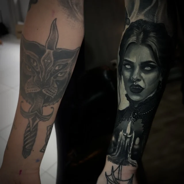 Vampira com vela cobrindo um gato no antebraço