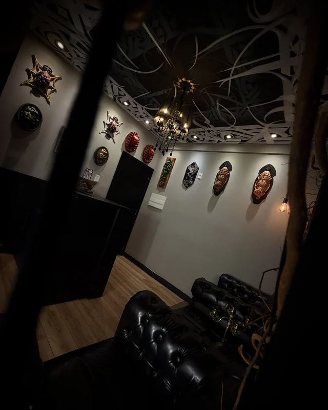 Sala de espera com máscaras na parede e lustre